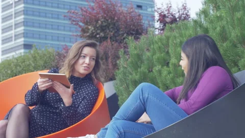 Two smiling students sharing information using a tablet computer outdoor Stock Footage 133042762