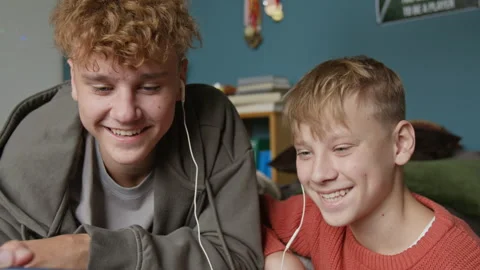 Two Smiling Teen Boys using Phone and Watching Videos Stock Footage 318553737