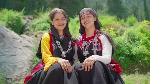 Two smiling young Indian Rural women wearing traditional attire sitting together Stock Footage 169977800