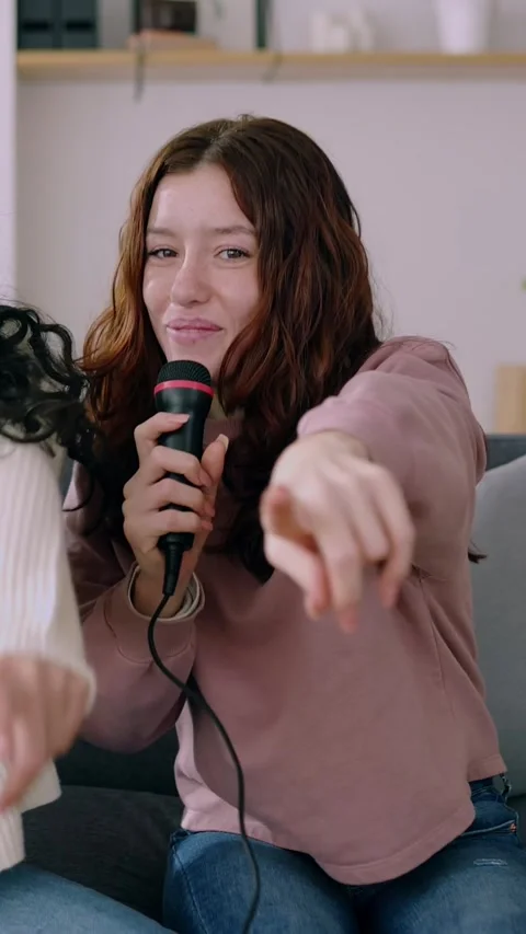 Two smiling young student roommates playing karaoke at home Stock Footage 245618556