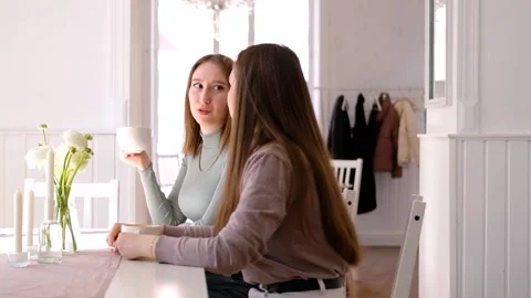 Two smiling young women in cafe drinking coffee and chatting Stock Footage 199581032