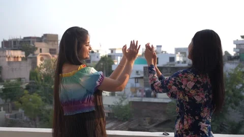 Two smiling  young women clapping hands together on roof. Vídeo Stock 146301526