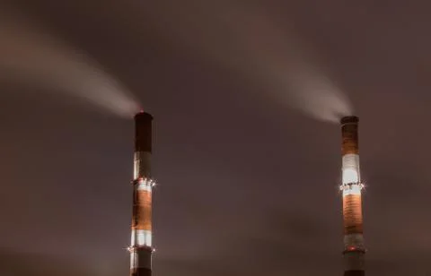 Two smoke stack against sky at night Stock Photos