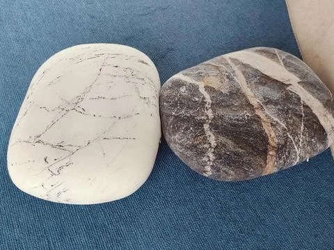 Two smooth, white and grey rocks. One is oval-shaped with no patterns on it.. Stock Photos