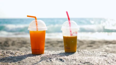 Two smoothies or juices on the beach with straws Stock Footage 220917825