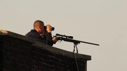 Two snipers aiming large gun and looking through goggles on roof top Stock Footage 43041653
