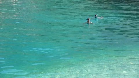 Two Snorkelers Explore the Crystal Clear Turquoise Waters of Serene Stock Footage 316221358