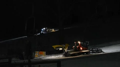 Two Snow Groomer Trucks Working at Night at Ski Hill Stock Footage 149689769