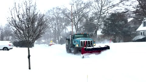 Two Snow Plows Clearing a Residential Street Early in a Snow Storm Stock Footage 327604873