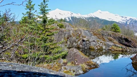 Two snowcapped Mountains reflected in a small pond Stock Footage 154384060