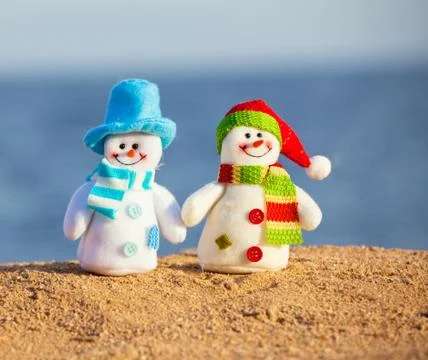 Two snowmans on sand Stock Photos