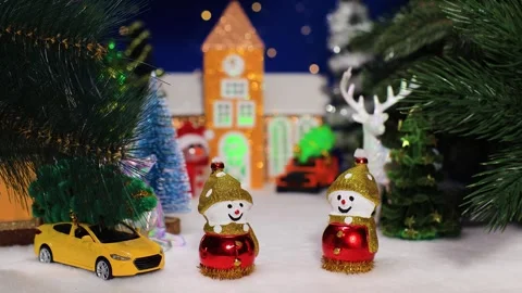 Two snowmen with a car against the backdrop of a chapel with a car and a snowman Stock Footage 344876653