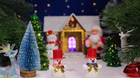 Two snowmen in front of Christmas trees and a house with Santa Claus Stock Footage 344876648