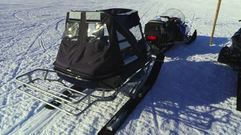 Two snowmobiles parked side by side on a snowy surface, ready for winter ad.. Stock Footage 287073120