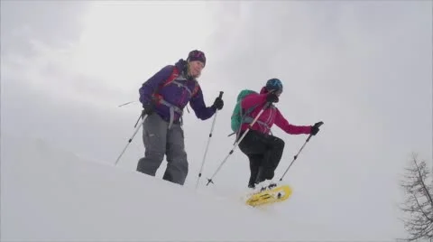 Two Snowshoers Take a Leap from a Mountainside. Vídeo Stock 59162248