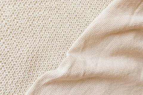 Two soft beige knitted blankets lying diagonally with copy space Stock Photos