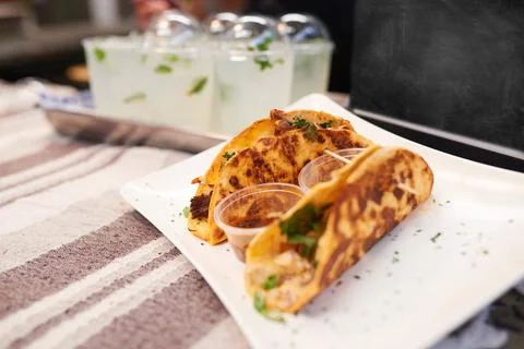 Two soft shell tacos with a chalkboard and lemonade at a market stall Stock Photos