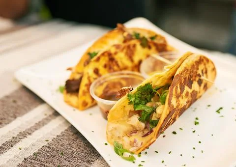 Two soft shell tacos at a market, one with chicken one with beef Stock Photos