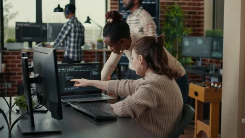 Two software coders analyzing source code looking for errors running on laptop Stock Footage 168248602