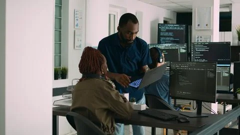 Two software coders analyzing source code looking for errors on laptop 库存照片