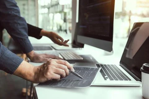 Two software developers are analyzing together about the code written into .. Stock Photos