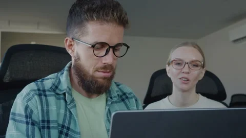 Two software developers are collaborating on project, reviewing code on laptop Stock Footage 312123159