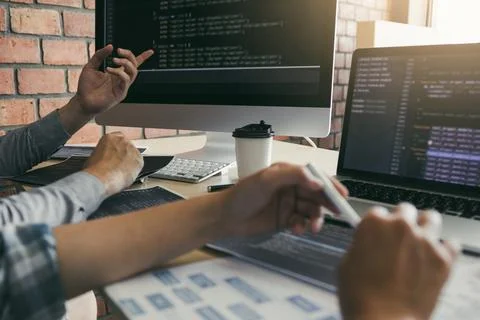 Two software developers are using computers to work together with their par.. Foto stock