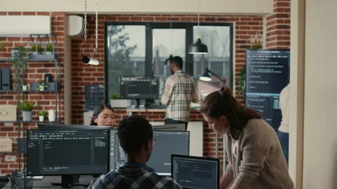 Two software developers doing high five hand gesture at desk with multiple Stock Footage 168237974
