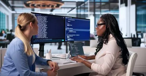 Two Software Developers Work Together On Coding Projects In Cloud Workspace. 库存照片
