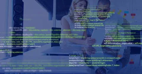 Two software devs coding at desk, typing causing code UI and charts showing bugs 스톡 사진