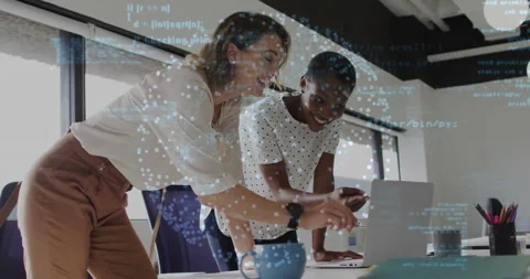 Two software engineers leaning over desk pointing code on laptop then reviewing Stock Footage 311916492