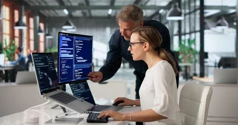 Two Software Engineers Working Together On Secure Code At Office Desk. 스톡 사진
