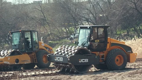 Two Soil skating rinks working to seal ground the base of road. Video stock 128112096