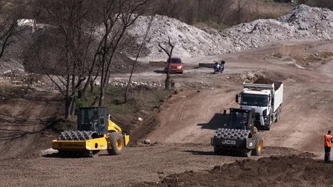 Two Soil skating rinks working to seal ground the base of road. Stock Footage 128251416