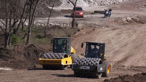 Two Soil skating rinks works to compress the base of road Stock Footage 128251446