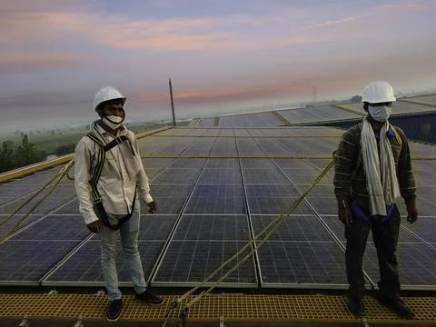Two solar Engineers are standing on walkway and wearing safety harness, white Foto stock