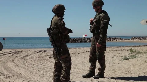 Two solders talk on beech Видео 76293918