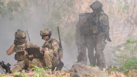 Two soldier look to map and discuss about the way to bring injury friends escape Stock Footage 133714300