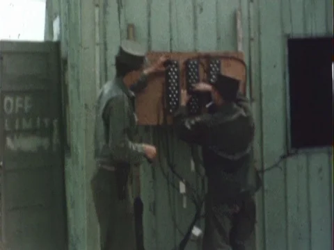 Two Soldiers Adjusting Wall Mounted Radio Equipment - Vintage 8mm Stock Footage 78925041