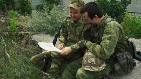 two soldiers are studying a map of the a... | Stock Video | Pond5