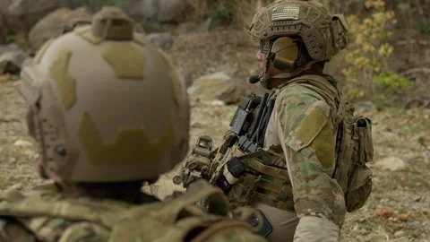 Two soldiers in full combat gear strategize Stock Footage 336747410