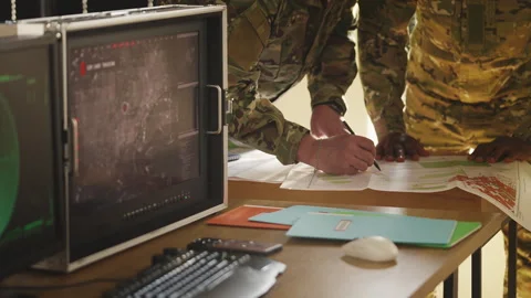 Two soldiers preparing operation plan using maps and surveillance data Stock Footage 335539545