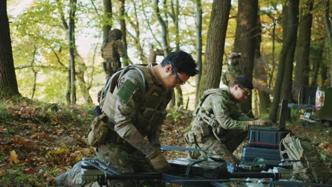 Two soldiers using laptop computer for surveillance during a military operations Stock Footage 241012165