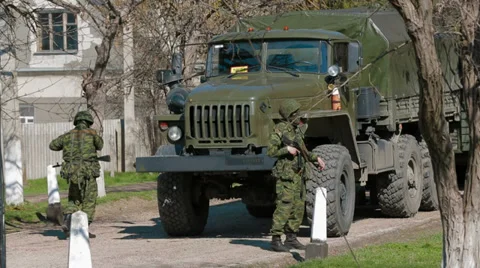 Two soldiers with weapons next to An armoured personnel carrier (APC) Stock Footage 35901557