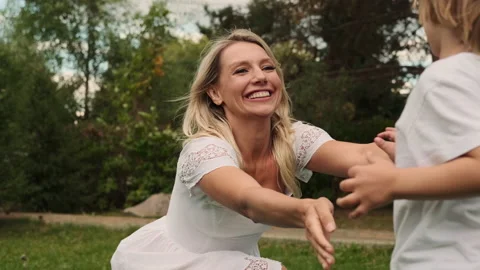 Two sons of different ages run to their mother and hug her. Stock Footage 217797513