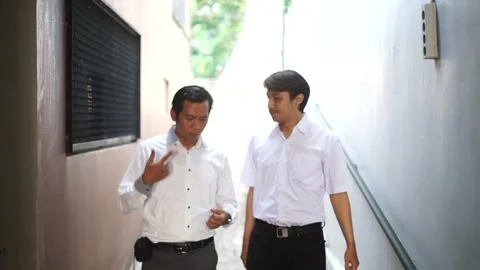 Two Southeast Asian men engage in a lively discussion about their business, Stock Footage 286071767