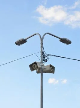 Two speakers on lamppost on a background of clouds and blue sky Stock-Fotos