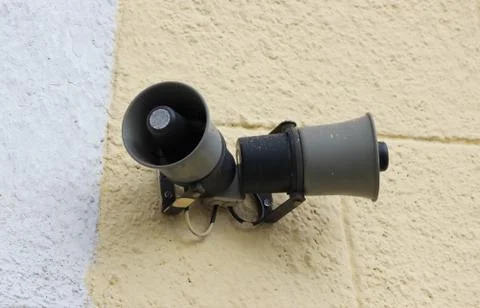 Two speakers at the train station on the background of beige wall plastered Stock Photos