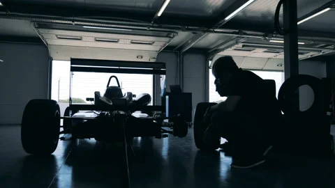 Two specialists are installing wheels on the racing cart Video stock 163505791