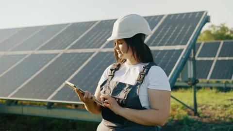 Two specialists work at a power plant with solar panels on a sunny day Stock Footage 261521673